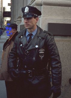 a man in a police uniform walking down the street