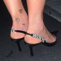 a woman's feet with tattoos on them and the word mean tattooed on her ankle