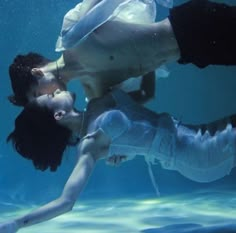 two people kissing under water in an aquarium