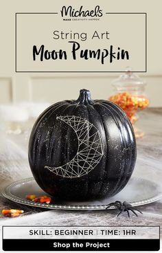 a black pumpkin sitting on top of a plate with the words, halloween string art moon pumpkin