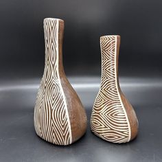 two brown and white vases sitting side by side