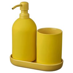 a yellow soap dispenser and cup sitting on a tray next to each other