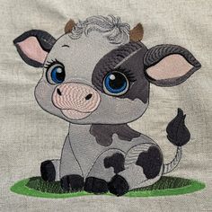 a close up of a small cow on a cloth material with blue eyes and ears