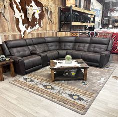 a living room with a large sectional couch and coffee table in it's center