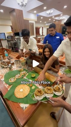 a group of people standing around a table filled with food