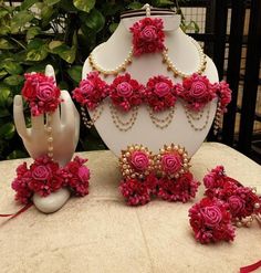 pink flowers and pearls are on display in front of a white vase