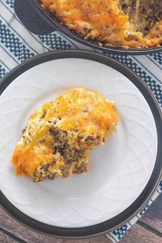 a piece of food on a plate next to a casserole dish with meat and cheese