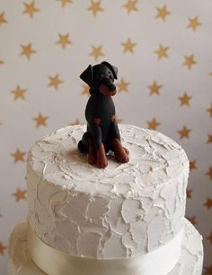 a small dog figurine sitting on top of a white cake