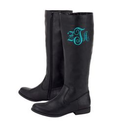 a pair of black boots with green monogrammed initials