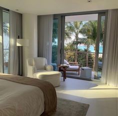 a bedroom with a bed, chair and sliding glass doors leading to an outside patio