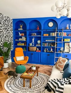 a living room filled with furniture and blue shelves