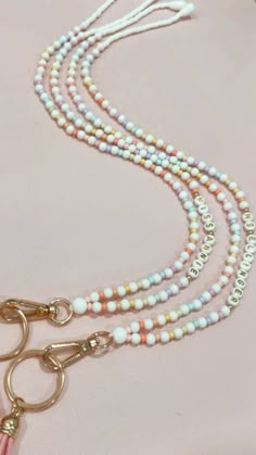 a necklace with beads and tassels is shown on a pink tablecloth,