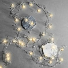 an assortment of lights and decorations on a gray tablecloth with a mirror in the middle