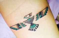 a small tattoo on the wrist of a woman's arm with an arrow and two arrows