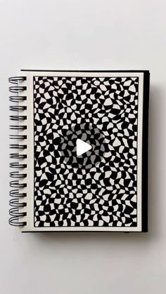 an open notebook with black and white designs on it