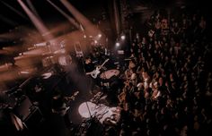 a group of people that are standing in front of some microphones and guitars on stage