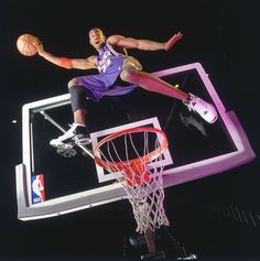 a basketball player jumping up into the air to dunk a ball in front of him