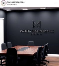 an empty conference room with black walls and wooden table in front of the logo for marecel de oliveira siva