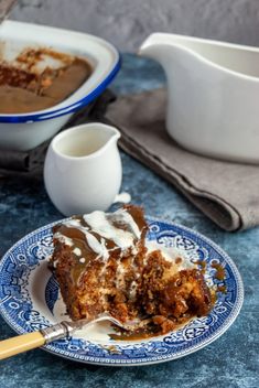 a piece of cake on a blue and white plate next to a bowl of pudding