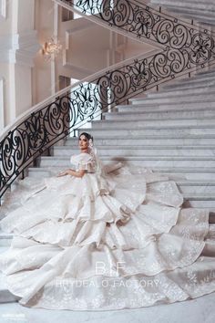 a woman in a wedding dress sitting on some stairs