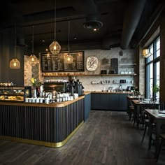 the interior of a coffee shop with wooden floors and black walls, along with hanging lights