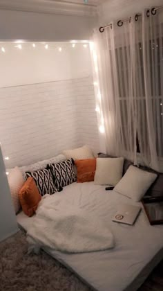 a white couch with pillows on it and a laptop computer sitting on top of it