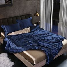 a bed with blue sheets and pillows in a room