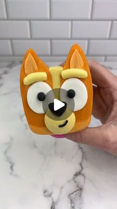 a person holding a small toy with a dog face on it