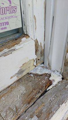 the corner of an old wooden window sill that has chipped paint on it