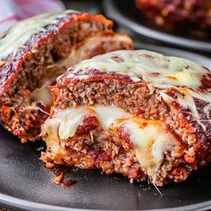 meatloaf stuffed with cheese and sauce on a black plate, ready to be eaten