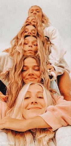 three women with blonde hair laying on top of each other