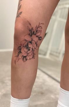 a woman's legs with flowers tattooed on them