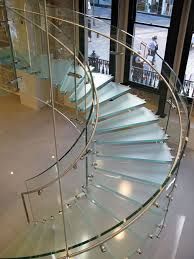 a spiral staircase with glass railings in a building