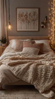 a bed with blankets, pillows and lights on the wall above it is decorated in neutral colors