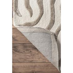 an area rug with wood flooring and white fabric on the bottom half of it