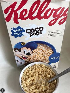 cereal in a bowl next to a carton of white choco pops on a table