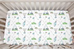 a baby crib with a golf theme on the bed sheet and pillow case in it