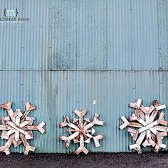 three snowflakes are placed on the side of a building with rusted metal siding