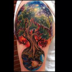 a woman's arm with a colorful tree on it and stars in the sky