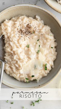 a bowl filled with mashed potatoes on top of a white countertop next to two silver spoons