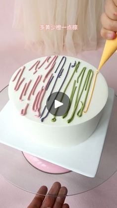 someone is cutting into a cake with colorful icing