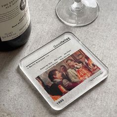 a bottle of wine sitting next to a glass on top of a marble countertop