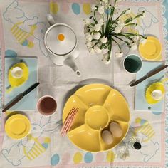 the table is set with yellow dishes and utensils for an easter breakfast or brunch