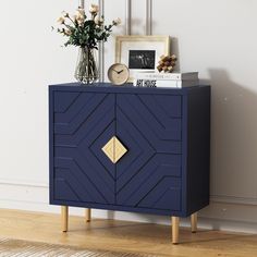 a blue cabinet sitting on top of a wooden floor next to a vase with flowers