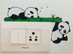 two pandas are playing on the electrical outlet cover