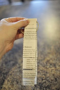 a person holding up a piece of paper that has been folded into the shape of a book