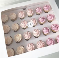 a box filled with pink and white cupcakes