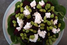 a salad with beets, feta cheese and spinach leaves on a plate