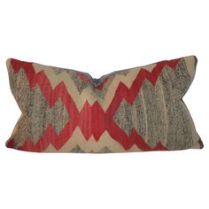 a red and grey pillow on a white background with an arrow pattern in the middle