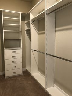 an empty walk in closet with white shelving